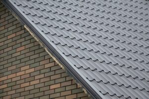 Modern brown roof made of painted metal. Corrugated metal roof and metal roofing industry concept